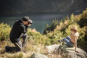 schöne frau, die zu ihrer freundkamera lächelt, während sie reisen foto