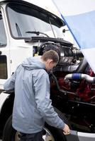 LKW-Fahrer prüft den Betrieb Motor-Sattelzug mit offener Motorhaube