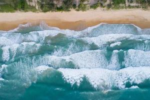 Luftbild Sandstrand und brechende Wellen am Sandstrand Schönes tropisches Meer am Morgen Sommersaisonbild von Luftbild-Drohne geschossen, Hochwinkelansicht von oben nach unten foto