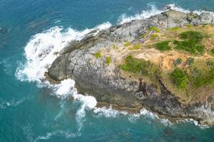 Luftaufnahme von oben nach unten Küste große Welle stürzt auf Felsen Klippe schöne Meeresoberfläche im sonnigen Tag Sommer Hintergrund erstaunliche Meereslandschaft Draufsicht Meeresküste in Phuket Thailand foto