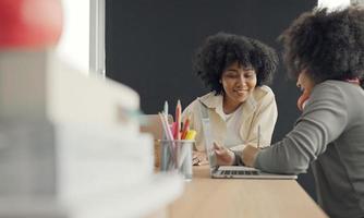 Klassenzimmer mit verschiedenen Lernenden von fröhlichen afroamerikanischen Schülern und Lehrern, die gemeinsam Aktivitäten unternehmen. Der Lehrer unterrichtet, leitet und spricht mit den Kindern in verschiedenen Bereichen. foto