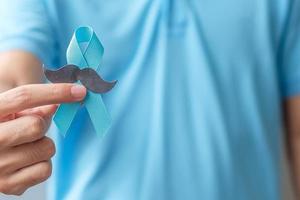 Monat des Bewusstseins für Prostatakrebs im November, Mann, der ein blaues Band mit Schnurrbart hält, um Menschen zu unterstützen, die leben und krank sind. gesundheitswesen, internationale männer, vater und weltkrebstageskonzept foto