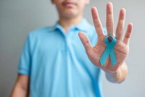 monat des prostatakrebsbewusstseins november, mann im blauen hemd mit der hand, die blaues band hält, um menschen zu unterstützen, die leben und krankheiten. gesundheitswesen, internationale männer, vater und weltkrebstageskonzept foto