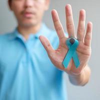 monat des prostatakrebsbewusstseins november, mann im blauen hemd mit der hand, die blaues band hält, um menschen zu unterstützen, die leben und krankheiten. gesundheitswesen, internationale männer, vater und weltkrebstageskonzept foto