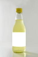 Glasflasche mit gelbem Wasser auf weißem Hintergrund foto