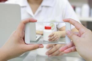 Fotografieren der Medikamentenflasche in der Apotheke foto