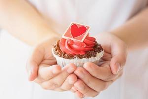 Valentinstag Cupcake in der Hand halten foto