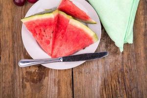 Wassermelonenscheiben auf dem Teller als nächstes mit Pflaumen foto