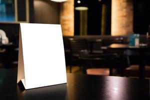 Mockup-White-Label-Menürahmen auf dem Tisch mit Café-Restaurant-Innenhintergrund foto