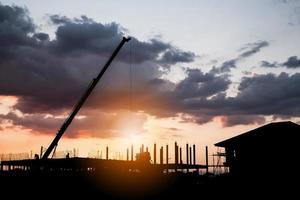 Silhouette Hausbau auf Baustelle Sonnenuntergang Hintergrund foto