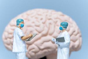 Miniatur-Chirurg, der das Gehirn des Patienten analysiert foto
