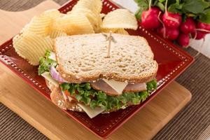 Schinken-Puten-Sandwich zum Mittagessen mit Kartoffelchips foto