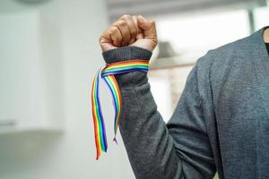 asiatische frau mit regenbogenflagge, lgbt-symbolrechten und geschlechtergleichstellung, lgbt-stolzmonat im juni. foto