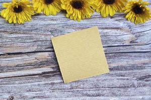 zerrissenes braunes papier auf holzoberfläche und sonnenblumenflachlage mit kopienraum. foto