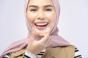 Eine junge muslimische Frau mit Invisalign-Zahnspangen im Studio, Zahnpflege und kieferorthopädisches Konzept. foto