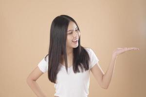 ein Porträt einer asiatischen Frau mit weißem T-Shirt über hellbraunem Hintergrund Studio foto