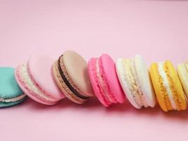 bunte französische Macarons Makronenkuchen, köstliches süßes Dessert auf einem rosa Hintergrund mit Kopienraum, Lebensmittelhintergrundkonzept. foto