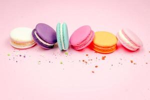 bunte französische Macarons Makronenkuchen, köstliches süßes Dessert auf einem rosa Hintergrund mit Kopienraum, Lebensmittelhintergrundkonzept. foto