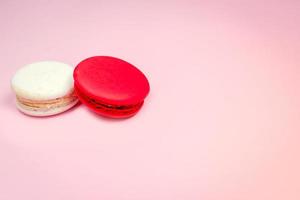 bunte französische Macarons Makronenkuchen, köstliches süßes Dessert auf einem rosa Hintergrund mit Kopienraum, Lebensmittelhintergrundkonzept. foto