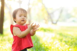 porträtgesicht des niedlichen asiatischen kleinen mädchens und des kindes glück und spaß im park im sommer, lächeln und glücklich vom asiatischen kind und entspannen im garten, lebensstil-kindheitskonzept. foto