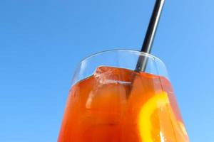 Erfrischende orangefarbene Sommercocktails mit Eis vor blauem Himmelshintergrund. foto