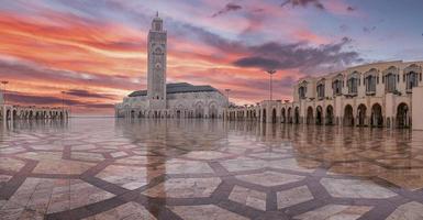 Flachwinkelansicht der historischen Moschee Hasan II mit dem höchsten Minarett gegen dramatischen Himmel foto