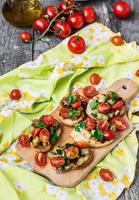 Bruschetta mit Zucchini, Speck, Frühlingszwiebeln und Kirschtomaten foto