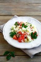Salat mit gekochtem Couscous und frischem Gemüse auf einem Teller foto