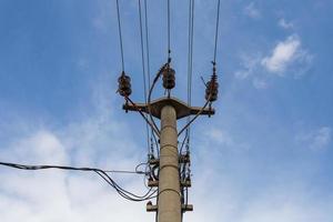 Verflechten von elektrischen Drähten mit Lichtern gegen den Himmel. Silhouette einer Säule foto