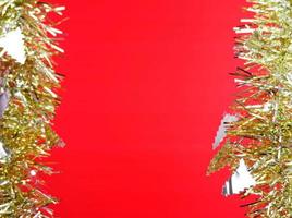 silberner weihnachtsbaum und goldband auf rotem hintergrund foto