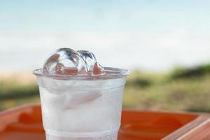 Eis in einem Glas Wasser und natürlichem Hintergrund foto