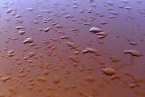 Wassertropfen nach Regen auf orangefarbenem Hintergrund foto