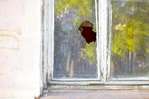 Das Fenster im Haus ist zerbrochenes Glas Rowdytum. foto