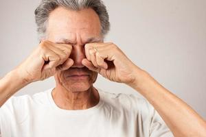 reifer mann, der sich morgens die augen reibt foto