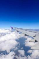 Flügel des Flugzeugs, das über den Wolken fliegt. Blick aus dem Fenster eines Flugzeugs foto