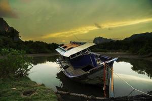 das kaputte schiff, ein altes verlassenes schiff am ozeanufer. thailändisches hölzernes motorboot. foto