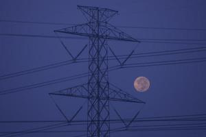 Hochspannungsmasten und Kabel mit Vollmondhintergrund am Morgen. Weicher Fokus. foto