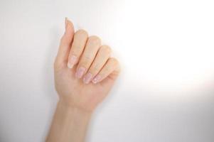 weiblicher Nagelschwächeschaden durch Gelpoliturbeschichtung, Fingernagelmaniküre. foto