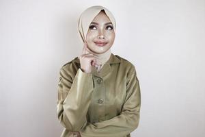 eine junge asiatische muslimische frau, die eine braune uniform und einen hijab trägt, der eine großartige idee denkt foto