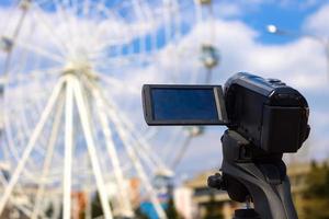 Camcorder schießt im Sommer ein Riesenrad in einem städtischen Vergnügungspark foto