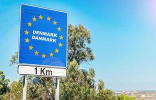 verkehrsschild an der grenze eines landes der europäischen union, dänemark 1 km voraus mit blauem himmel kopierraum foto