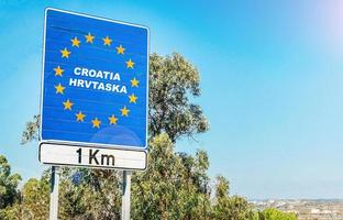verkehrsschild an der grenze eines landes der europäischen union, kroatien 1 km voraus mit blauem himmel kopierraum foto
