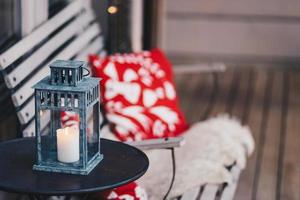 horizontale Aufnahme von Kerzenlicht auf rundem Tisch, weiße Holzbank mit rotem Kissen im Hintergrund. dekorierter gemütlicher Ort für Ihre Erholung und Entspannung foto