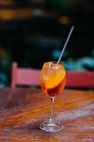 Schuss frischer Sommercocktail mit Orange und Eis im Weinglas. aperol spiritz cocktail in bar ohne menschen. unscharfer Hintergrund. Getränk für die Party foto