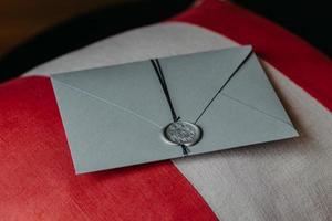 Innenaufnahme der eleganten Einladungskarte aus grauem Papier liegt auf dem Sofakissen. einladung zum jahrestag oder zur hochzeit. Dekoration foto