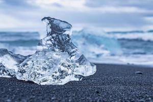 Nahaufnahme eines schönen Eisbergstücks am Ufer des schwarzen Sandes am Diamond Beach foto