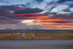 Schilder auf der Straße auf Vulkanlandschaft gegen dramatischen Himmel bei Sonnenuntergang foto