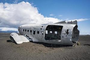 Verlassenes Militärflugzeugwrack am schwarzen Sandstrand in Solheimasandur gegen den Himmel foto