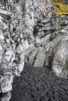 blick auf die wunderschönen basaltsäulen am berühmten reynisfjara-strand gegen bewölkten himmel foto