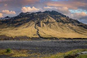 Malerischer Blick auf den majestätischen Berg gegen bewölkten Himmel bei Sonnenuntergang foto